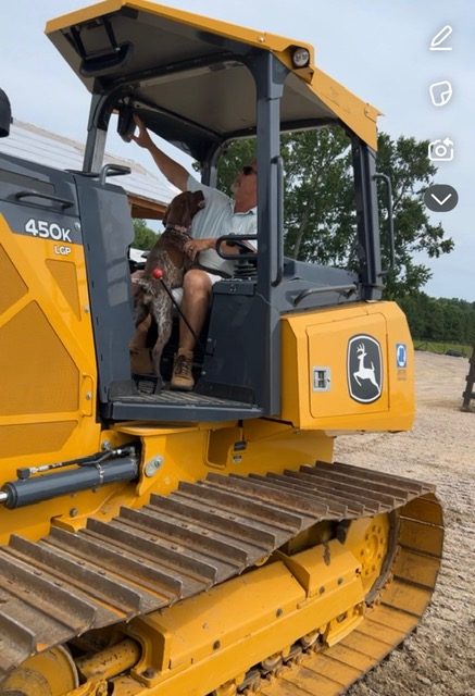 Aspen Partners owner and the company dog in a John Deere dozer